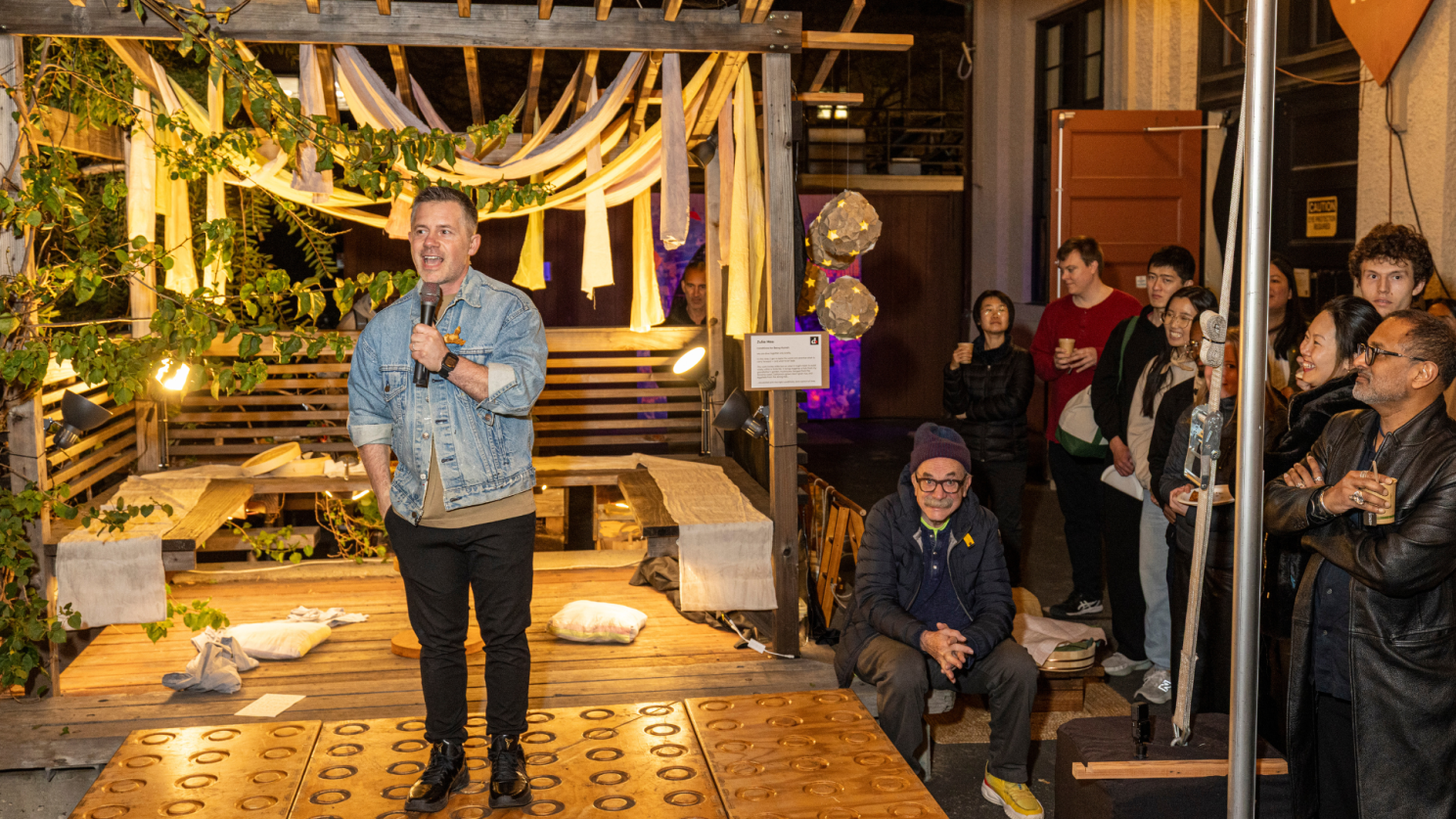 Shawn at the mic, speaking to the crowd at Personal Statements — my advisor David Kelley in the audience